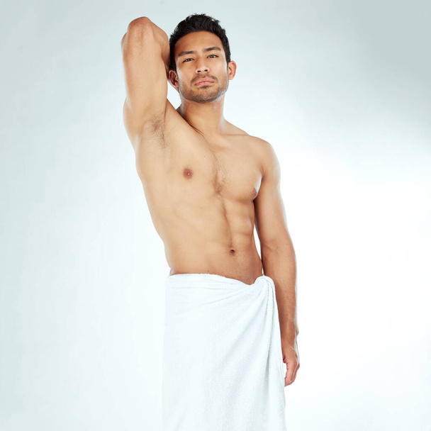 a handsome young man posing in a towel against a studio background. - Foto, Bild