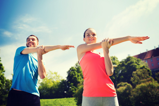 smiling couple stretching outdoors - Foto, Imagen