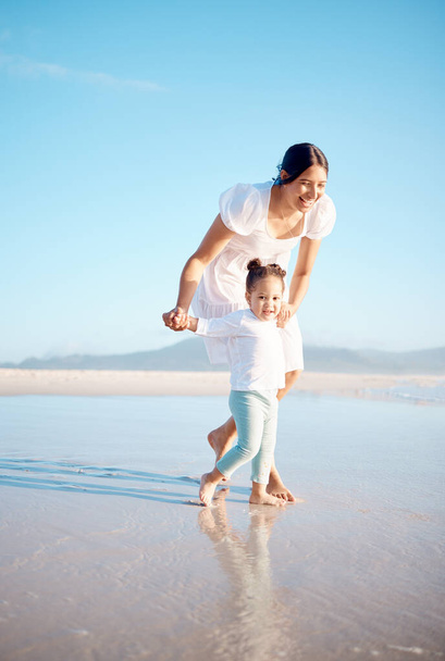 a young woman at the beach with her adorable daughter. - Foto, Imagen