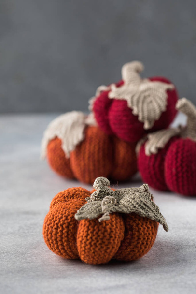  Knitted handmade pumpkins on a grey background. The concept of autumn and coziness. DIY decor. - Foto, imagen