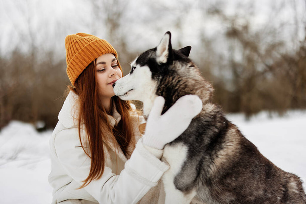 wesoła kobieta w śniegu bawiąca się z psem na świeżym powietrzu przyjaźń. Wysokiej jakości zdjęcie - Zdjęcie, obraz