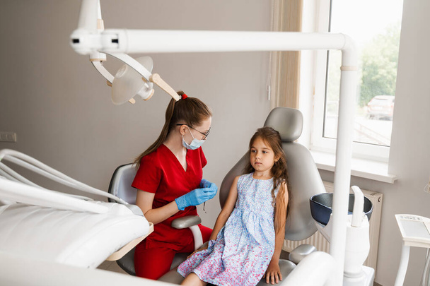 Child girl afraid dentist. Childrens dentist consults frightened kid in dentistry. Treatment of teeth and toothache in children - Foto, Imagem