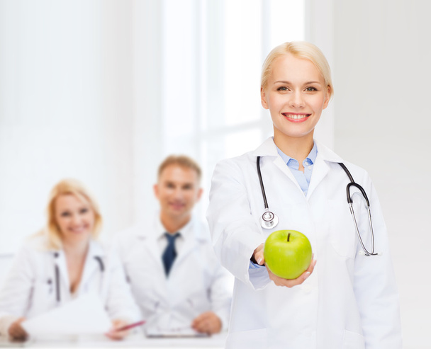 青リンゴと笑みを浮かべて女性医師 - 写真・画像