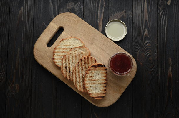 Ev yapımı çilek reçelli tost ekmeği ve kahvaltıda ya da kahvaltıda tereyağlı köy masası.. - Fotoğraf, Görsel