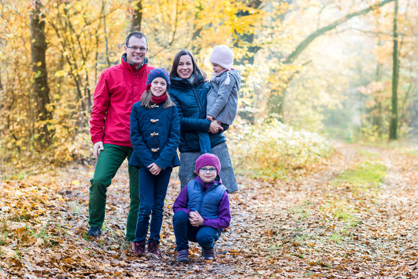 Happy father, mother and daugters on an autumn day - Foto, imagen