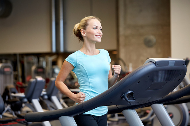smiling woman exercising on treadmill in gym - Foto, Imagem
