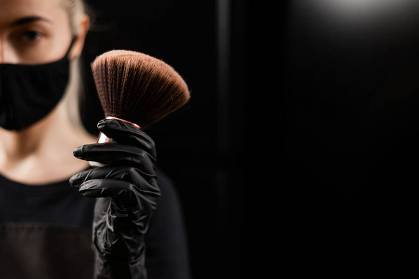 A woman is holding a powder brush. Body care after an instant tan - Foto, Bild
