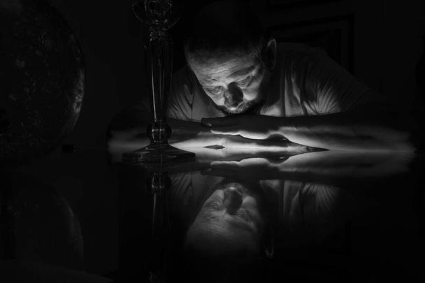 Schwarz-weiße Großaufnahme eines auf Glas liegenden Männergesichts mit Spiegelung. Salvador, Bahia, Brasilien. - Foto, Bild