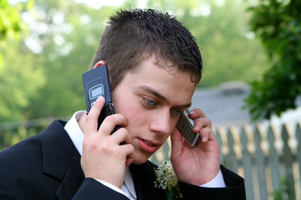 Prom jongen op twee telefoons - Foto, afbeelding