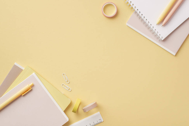 Back to school concept. Top view photo of stationery diaries pens ruler clips and adhesive tape on isolated pastel yellow background with copyspace - Photo, Image