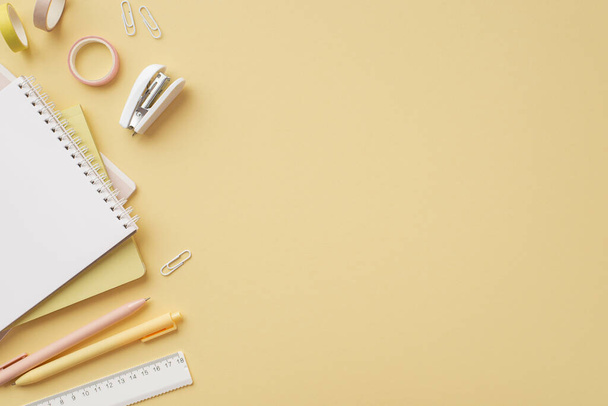 Back to school concept. Top view photo of school accessories copybooks ruler pens clips mini stapler and adhesive tape on isolated pastel yellow background with copyspace - Φωτογραφία, εικόνα