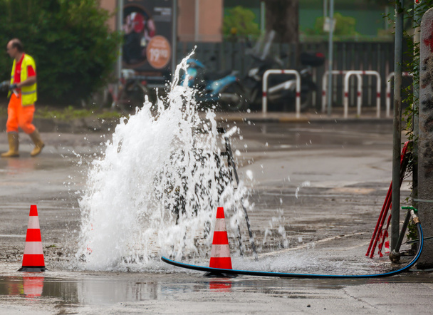 por carretera chorro de agua al lado de conos de tráfico
 - Foto, Imagen