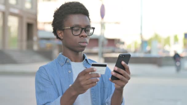 Spannende Afrikaanse man online winkelen via smartphone, Outdoor - Video