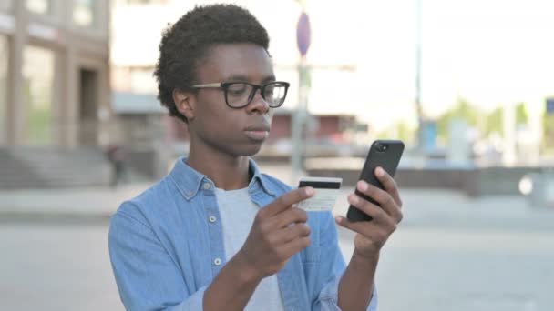 Upset African Man Reacting to Loss on Smartphone Outdoor - Metraje, vídeo