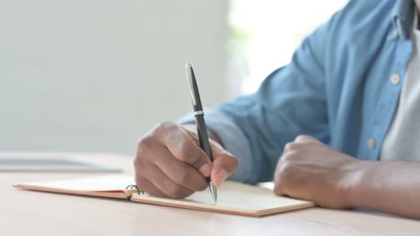 Close Up of African Man Writing on Notebook - Video, Çekim