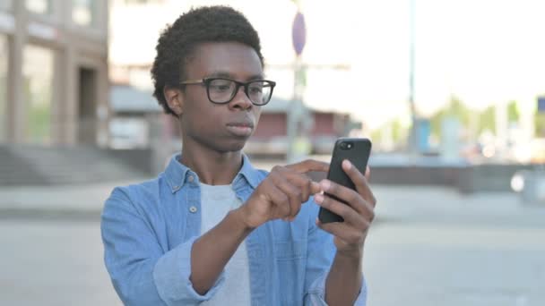 African Man Browsing Internet on Smartphone Outdoor - Metraje, vídeo