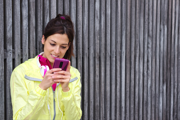 Female athlete texting message on smartphone - Zdjęcie, obraz