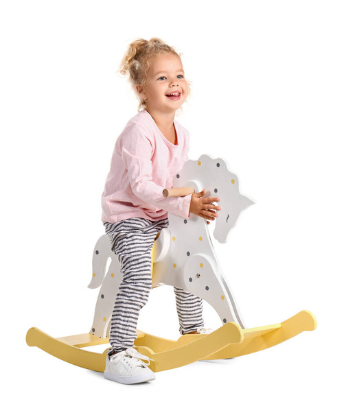 Adorable little girl with rocking horse on white background - Φωτογραφία, εικόνα