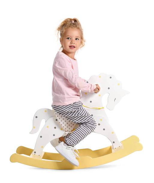 Suloinen pieni tyttö keinuvat hevonen valkoisella taustalla - Valokuva, kuva