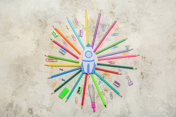 Paper rocket with school stationery on light background - 写真・画像