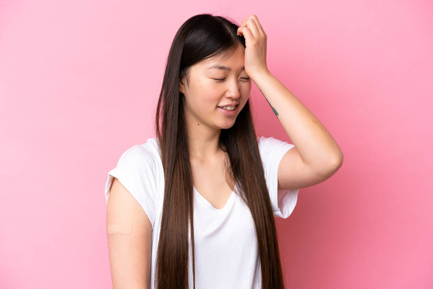 Young Chinese woman wearing a band aids isolated on pink background has realized something and intending the solution - Photo, Image