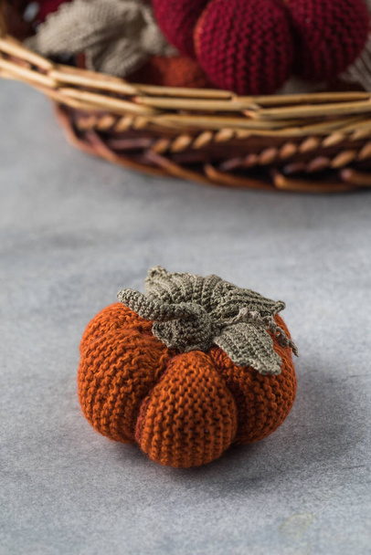  Knitted handmade pumpkins on a grey background. The concept of autumn and coziness. DIY decor. - Foto, imagen