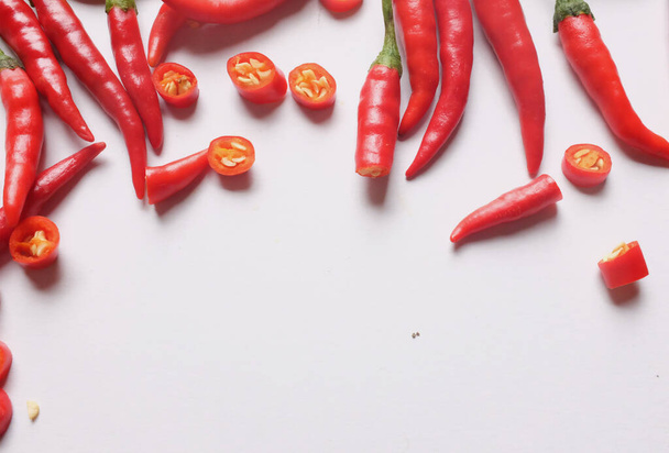 Стиглі червоні гарячі перець чилі нарізані шматочками овочів ізольовані на білому тлі. приготування інгредієнтів
 - Фото, зображення