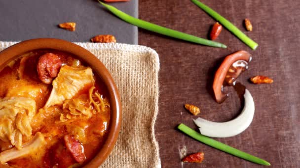 Calos tapa comida típica espanhola, com chouriço e vários de seus ingredientes no lado em um fundo de madeira e ardósia - Filmagem, Vídeo