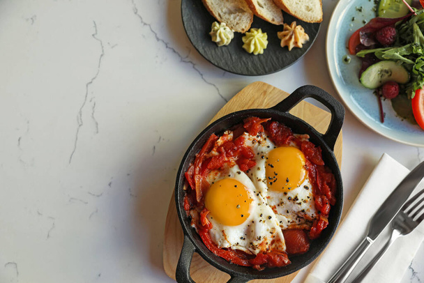 Tasty Shakshouka served on white marble table, flat lay. Space for text - Foto, Imagen