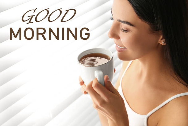 Good Morning! Young woman with cup of tea near window - Фото, зображення