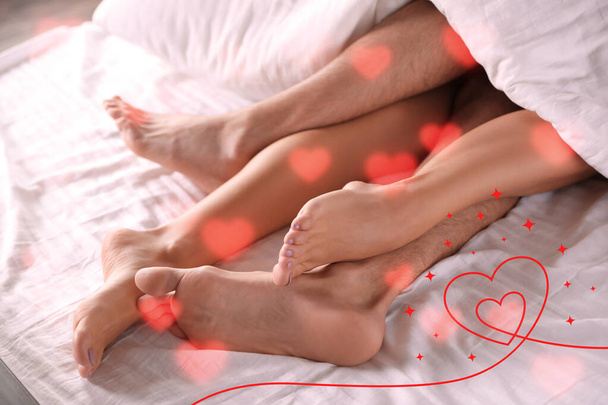 Illustration of hearts and passionate young couple having sex on bed at home, closeup of legs - Valokuva, kuva