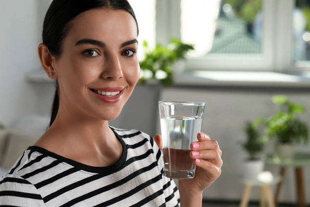 Young woman with glass of water indoors, closeup. Refreshing drink - Foto, Imagem