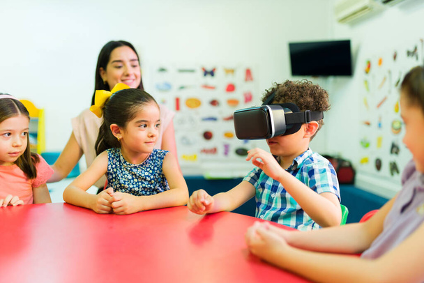 Bambini dell'asilo con occhiali di realtà virtuale che imparano lezioni prescolastiche con tecnologia futuristica - Foto, immagini