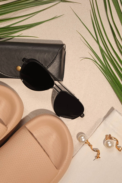 Flat lay composition with stylish sunglasses and black leather case on sand - Φωτογραφία, εικόνα