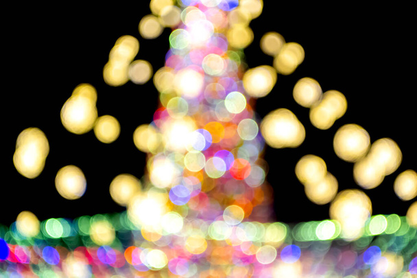 Grand sapin de Noël du Nouvel An décoré avec des guirlandes multicolores lumineuses et un éclairage nocturne. Arbre de Noël avec lumières clignotantes. Fond flou. Nouvel An et vacances de Noël - Photo, image