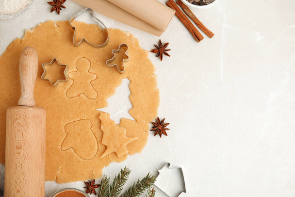 Flat lay composition with dough and cookie cutters on white table, space for text. Christmas biscuits - Фото, изображение