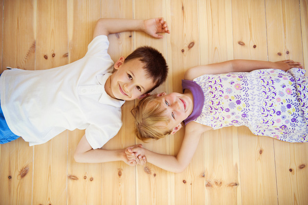 Two kids lying down on the floor - Foto, Imagem