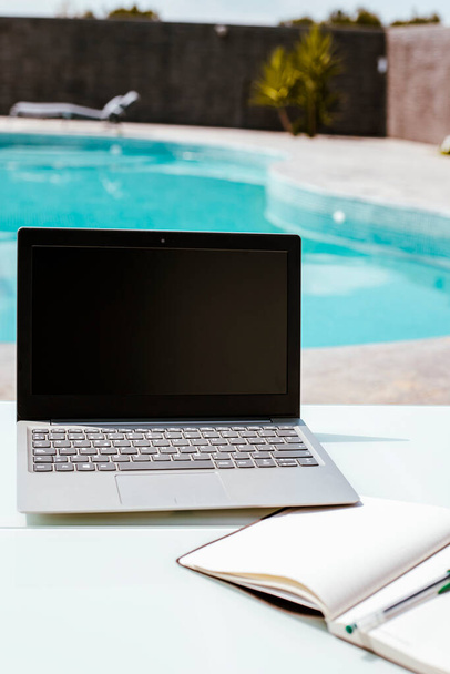 laptop in the pool, telecommuting from home, with the office in the pool - Photo, Image