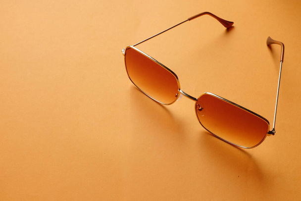  vista dall'alto un occhiali da sole isolare su uno sfondo aranciato.accessori moda donna moderna - Foto, immagini