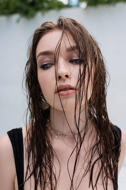 Trendy brunette woman with wet hair looking away at resort  - Foto, immagini