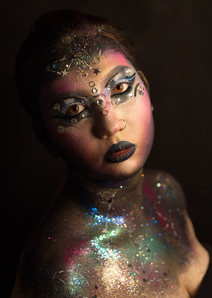 Portret van jong vrouwelijk model met creatieve make-up, strass en piercing - Foto, afbeelding