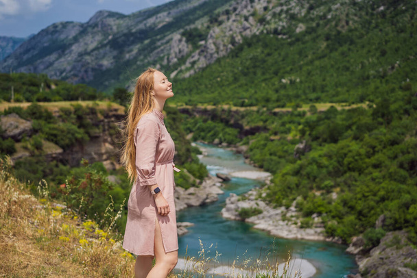 Woman tourist on background of purest waters of the turquoise color of the river Moraca flowing among the canyons. Travel around Montenegro concept. - Foto, imagen