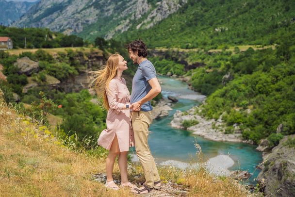 Couple man and woman tourists on background of purest waters of the turquoise color of the river Moraca flowing among the canyons. Travel around Montenegro concept. - Photo, Image