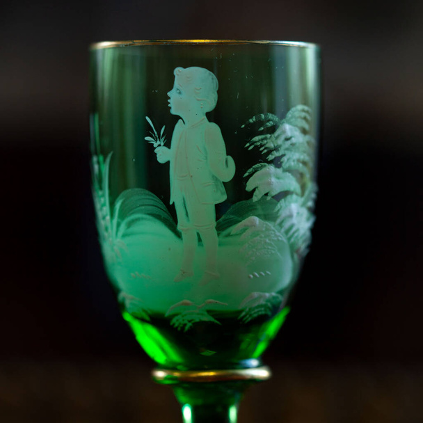 green glass wineglass in luxury interior. green glass with engraving close-up. bohemian glass closeup - Foto, immagini