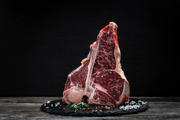 T-bone nebo porterhouse steak z hovězího masa nakrájeného z krátkých hřbetů. Steak zahrnuje kosti ve tvaru T s masem na každé straně. Steaky Porterhouse se krájejí ze zadního konce krátkých hřbetů. - Fotografie, Obrázek