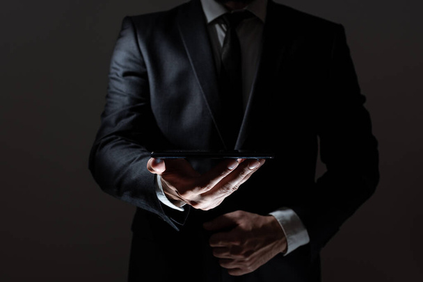 Podnikatel drží tablet s jednou rukou a představuje důležitá data - Fotografie, Obrázek