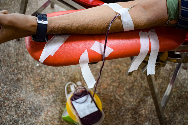 Донор крови в лагере для сдачи крови проводится с надувным мячом, держащимся за руки в храме Баладжи, Вивек Вихар, Дели, Индия, Изображение для Всемирного дня донора крови 14 июня каждый год, Лагерь сдачи крови - Фото, изображение