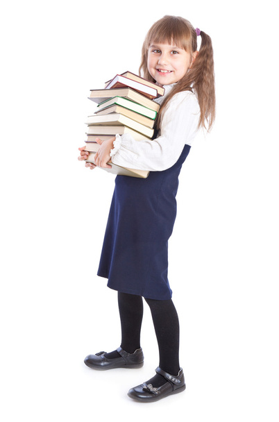 A smiling girl with a huge pile of books - Фото, изображение