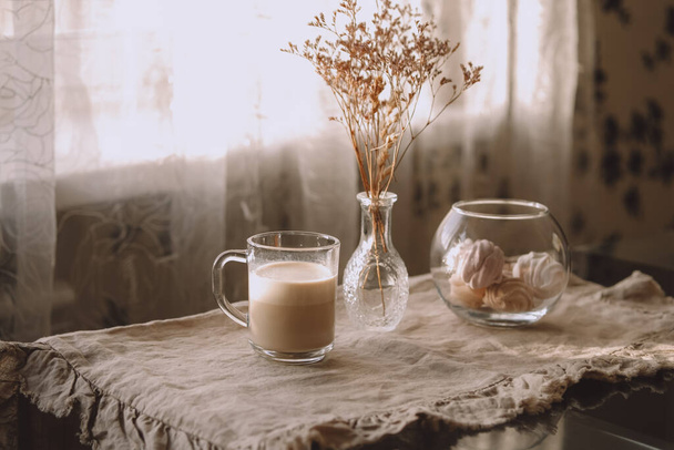 Table with a cup of tea or coffe in beige colors. Winter morning. - 写真・画像