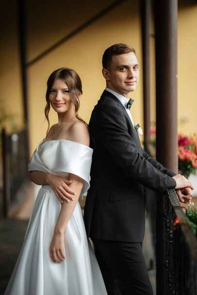 young couple bride and groom in a white short dress walking in the rain - Foto, imagen